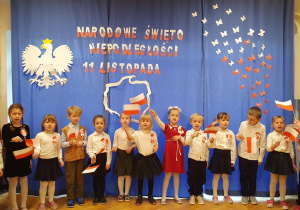 Dzieci śpiewają piosenkę i prezentują flagi